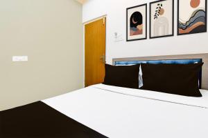 a bedroom with a white bed with black pillows at Hotel O Sunshine in Sāntrāgāchi +21 photos