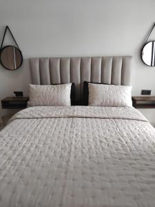 a bedroom with a large white bed with two pillows at Hamza Fahim in Kenitra