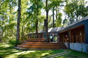 a house with a large wooden deck in the woods at Refugio de Paz y Naturaleza en Pucón in Pucón