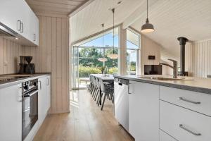 a kitchen with white cabinets and a table with chairs at 30439-Odder-Strandvaenget-74 in Odder