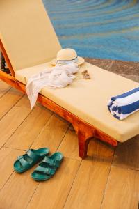 una cama con un sombrero y un par de chanclas en Sunday Hotel Chandigarh Zirakpur, en Zirakpur