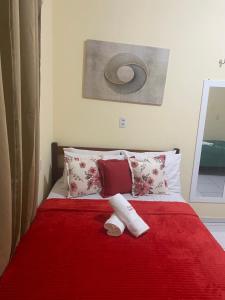 a bed with a red blanket and a sock on it at Pousada ExtraLar in Fortaleza