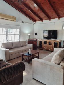 a living room with two couches and a tv at La quinta in Esquina