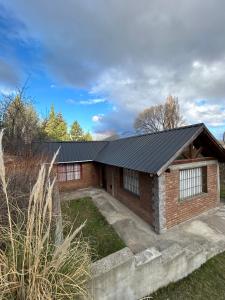 a brick house with a black roof at casa pie de la montaña in Esquel +7 photos