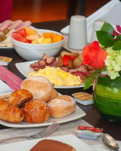 a table with plates of breakfast food on it at Sol de Oro Hotel & Suites in Lima