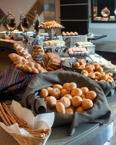 a table with several baskets of bread and pastries at Sol de Oro Hotel & Suites in Lima +46 photos