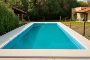 a blue swimming pool in a yard at El Rincón del Molle in Merlo