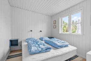 two pillows on a bed in a room with a window at 40385-Juelsminde-Firkanten-5 in Sønderby