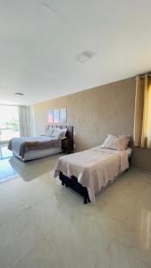a bedroom with two beds and a large window at Casa Grande Angra de Ipioca in Maceió +43 photos