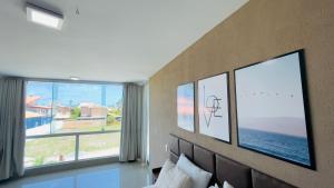 a bedroom with a large window with the ocean at Casa Grande Angra de Ipioca in Maceió