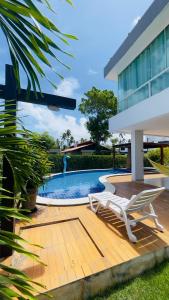 eine Terrasse mit zwei Liegestühlen neben einem Swimmingpool in der Unterkunft Casa Grande Angra de Ipioca in Maceió