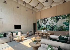 Un vestíbulo con sofás y mesas y plantas en la pared. en Arom Wongamart by David Home, en Norte de Pattaya