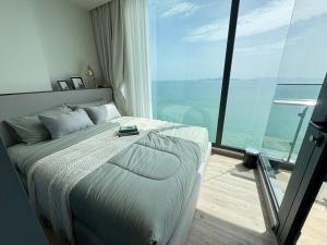 Un dormitorio con una cama grande y una ventana grande. en Arom Wongamart by David Home, en Norte de Pattaya 100 fotos más