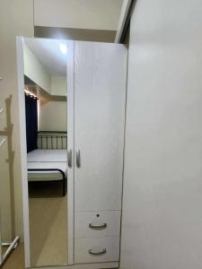 un armario con espejo y una cama en una habitación en CDO cityscape CONDO, en Cagayan de Oro 1 foto más