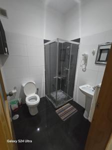 a bathroom with a shower and a toilet and a sink at My Flat 2 in Praia +26 photos