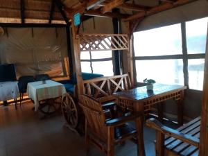 a room with a bed and a table and some windows at Modipane Guest Lodge in Tlokweng