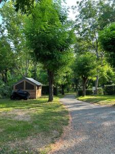 a small building in a park next to trees at Camping Beaussement Baroudeur in Chauzon