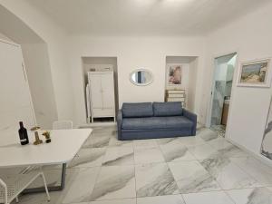 Una sala de estar con un sofá azul y una mesa. en Sea & Sun, en La Spezia