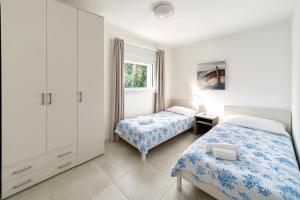 a bedroom with two beds and a window at Villa Greif in Lignano Sabbiadoro +66 photos