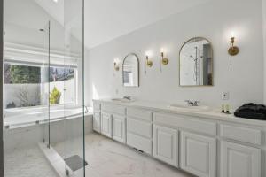 a white bathroom with two sinks and a shower at Vancouver Retreat in Vancouver +60 photos