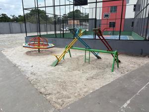 a playground with two play equipment in the sand at Apto c TV Streaming Ar Wifi e Piscina in Ananindeua
