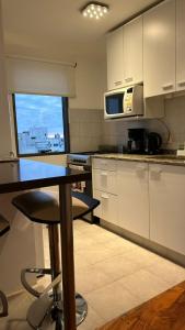 a kitchen with a table and a microwave at Depto Categoria Plaza Paso con opcion de cochera By Lofter in La Plata