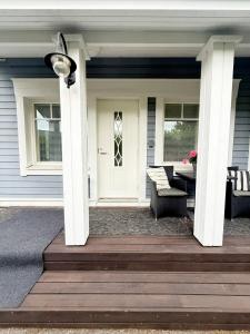 Un porche con columnas blancas y una puerta blanca. en Ihana Helmi - The Nest for Two, en Vaasa