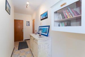 Una habitación con una pared blanca con una mesa y libros. en Mar i Munt, en Banyuls-dels-Aspres