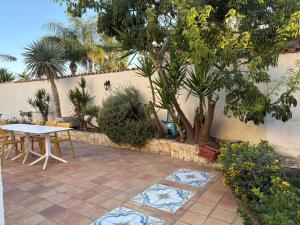 a patio with a table and a tree at Baia Monoi in Siracusa