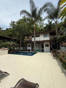ein Resort mit Swimmingpool und Palmen in der Unterkunft Perequê Vilarejo Ilhabela in Ilhabela