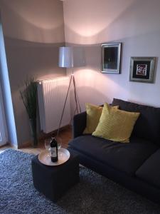 a living room with a black couch and a lamp at Garten86 in Bremen