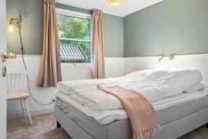 a bedroom with a bed with a window and a blanket at 40575-Juelsminde-Pot-Strandby-100 in Sønderby +25 photos