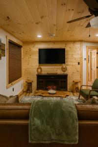 a living room with a couch and a flat screen tv at The Brady Retreat Hot tub and pool in McArthur