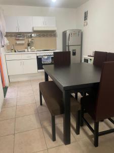 cocina con mesa negra, sillas y nevera en Gran casa de descanso, en Tezoyuca 7 fotos más