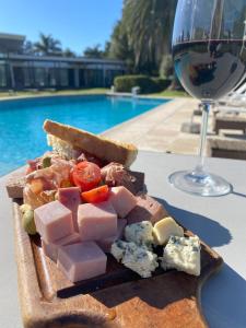 a plate of food next to a glass of wine at Hotel Camberland in Pilar