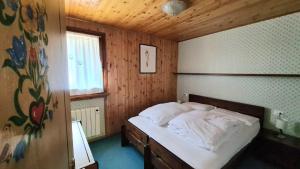 a bedroom with a bed in a wooden room at Nevi Apartment in Folgarida