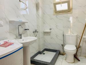 エル・アラメインにあるروف فيلا بقريه جرين بيتش تشطيب السنه ومودرنの洗面台とトイレを備えた白いバスルーム +20枚の写真