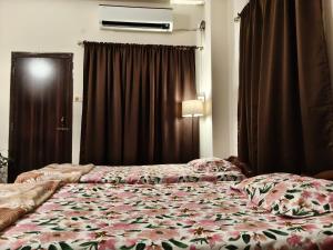 Un dormitorio con una cama con una colcha floral. en Mimo's, en Guwahati