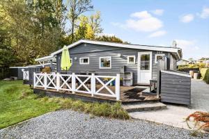 a tiny house with a fence in the yard at 40388-Juelsminde-Frede-Juels-Vej-244 in Sønderby