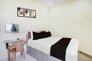 Un dormitorio con una cama, un escritorio y una silla. en Hotel O Century grand luxury rooms, en Warangal