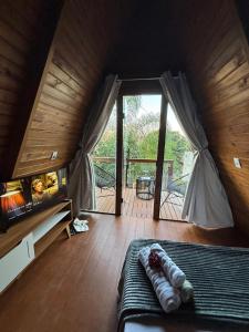 a room with a bed and a large glass door at Skychale in Governador Valadares