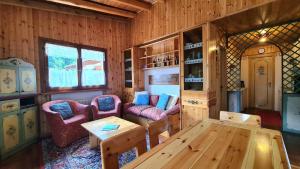 a living room with two chairs and a wooden table at Nevi Apartment in Folgarida