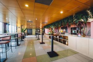 a restaurant with tables and plants on the walls at Leonardo Hotel IJmuiden Seaport Beach in IJmuiden