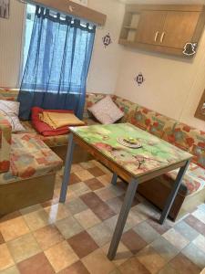 una sala de estar con una mesa y un sofá en le 130 locadelphine, en Meschers-sur-Gironde