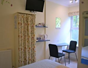 a bedroom with a bed and a table and two chairs at Little Bullocks Farm in Takeley
