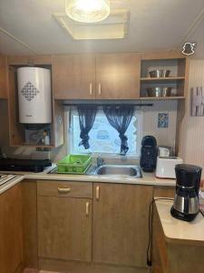 una cocina con fregadero y ventana en le 130 locadelphine, en Meschers-sur-Gironde