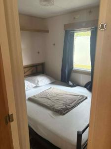 a bed in a small room with a window at le 130 locadelphine in Meschers-sur-Gironde