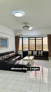 a living room with a couch and a table at Likas Square serviced apartment with garden view in Kota Kinabalu