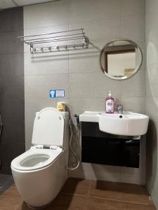a bathroom with a toilet and a sink and a mirror at Likas Square serviced apartment with garden view in Kota Kinabalu