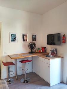 a kitchen with a desk with two stools and a tv at Chez Nous in La Spezia
